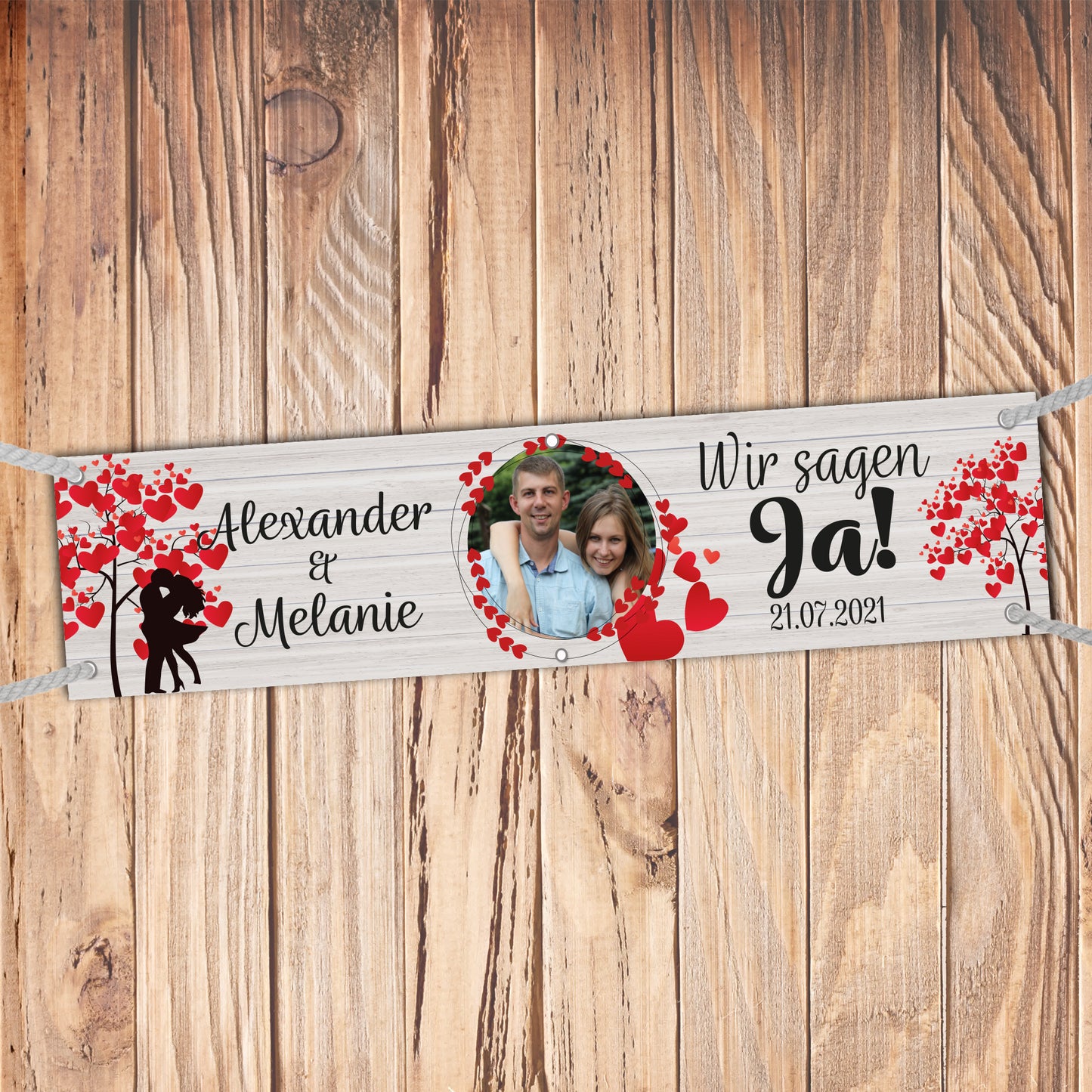 Hochzeitsbanner mit Foto und Namen personalisierbar. Schriftzug.: "Wir sagen ja" Abnner auf Holzhintergrund. Mit roten Herzen mit Liebespaar Silhouette unter Herzen Baum.